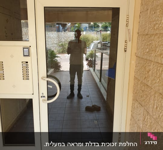 דלת זכוכית עם השתקפות אדם